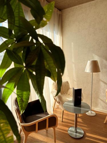 a living room with a table and a plant at Brit Hotel & Spa Saint Brieuc Plérin in Plérin
