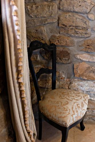 a chair sitting in front of a stone wall at Casa Rural Gite El Tossal in Collfred