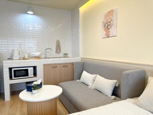 a living room with a couch and a table at ห้องพักเมืองทองธานี Happiness Sleep P1 in Ban Song Hong