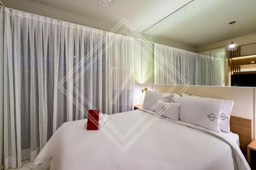 a bedroom with a large white bed and a mirror at Zainalofts7 Perdizes- Ao lado Allianz Parque 212 in Sao Paulo