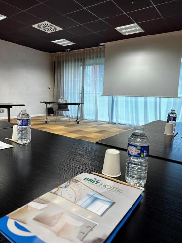 a conference room with two bottles of water on a table at Brit Hotel & Spa Saint Brieuc Plérin in Plérin