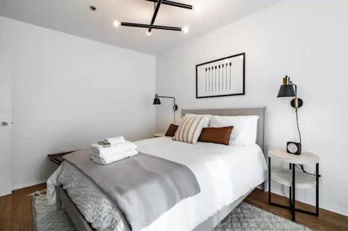 a bedroom with a white bed and a ceiling fan at Cute 1Bed Loft at The Foundry - Steps to Riverside in Cleveland