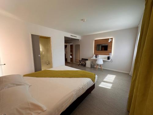 a hotel room with a bed and a bathroom at Brit Hotel & Spa Saint Brieuc Plérin in Plérin