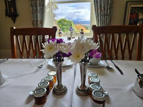a table with jars and flowers on a white table cloth at Craggan in Ballater