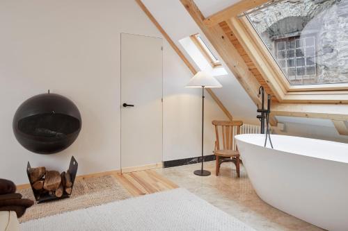 un bagno con una grande vasca bianca in mansarda di Era Artiga by FeelFree Rentals a Les Bordes