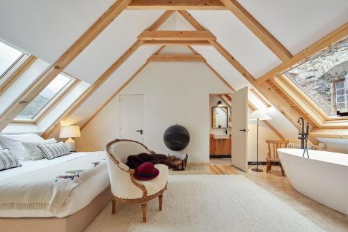 una camera da letto mansardata con un letto e una vasca da bagno di Era Artiga by FeelFree Rentals a Les Bordes