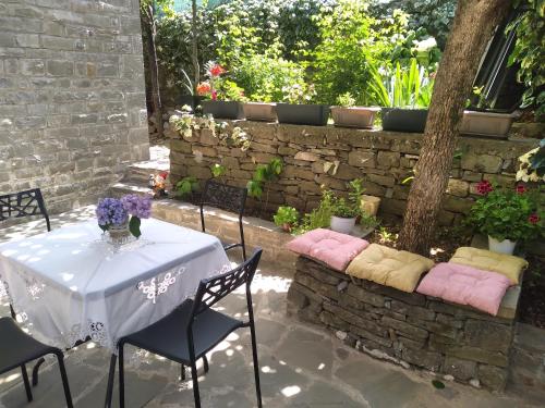 a table with pink and yellow pillows on a patio at Shtepia e Trendafilave in Përmet