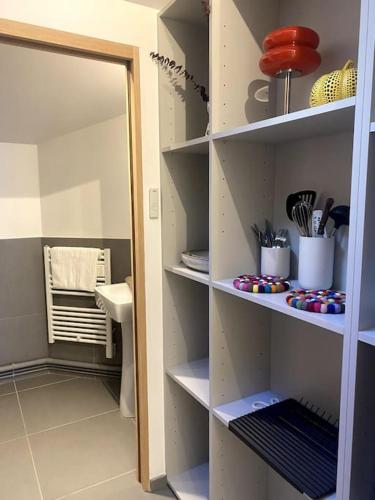 - un garde-manger avec des étagères blanches et des ustensiles dans l'établissement Modern parisian flat in Montparnasse area, à Paris