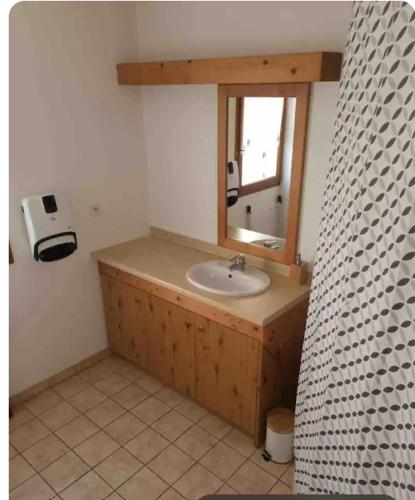 une salle de bain avec un lavabo et un miroir dans l'établissement Petit cocon entre lac, golf et montagne, proche d'Annecy, à Giez