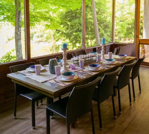 a large wooden table with chairs and a tableasteryasteryasteryasteryasteryasteryastery at Tots Cabin of Braeloch in Colchester