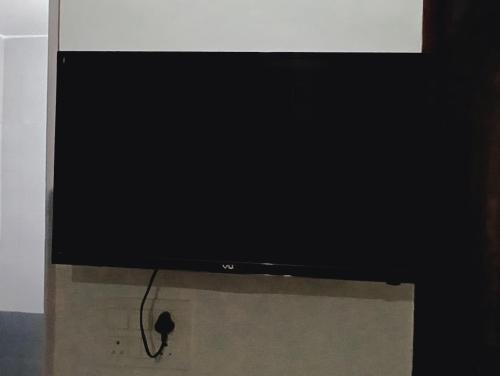 a flat screen tv sitting on top of a box at Metro Connected Homestay with Parkview in Greater Noida