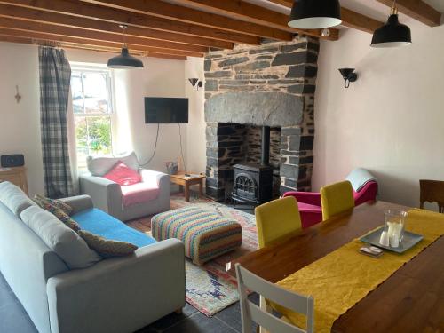 a living room with a couch and a table and a fireplace at Pen y Cwm in Penmachno