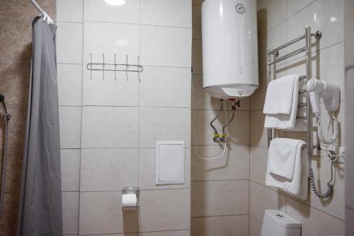 a bathroom with a shower and a toilet and a sink at Hotel BUTTERFLY in Sadove