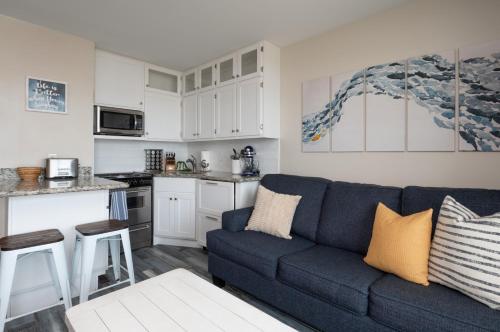 a living room with a blue couch and a kitchen at CDM 304 - Beachfront Serenity in Galveston