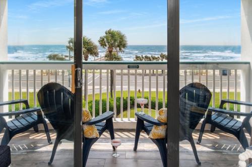 a balcony with chairs and a view of the ocean at CDM 304 - Beachfront Serenity in Galveston