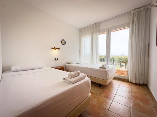 two beds in a room with a window at Beachfront Apartment Primera Línea 2-06 in Orihuela