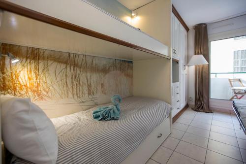 - une poupée assise sur un lit dans une chambre dans l'établissement Studio palais des arts, à Nice