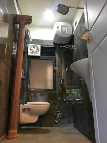 a bathroom with a toilet and a sink and a mirror at VIA VARANASI-A Boutique Hotel in Varanasi