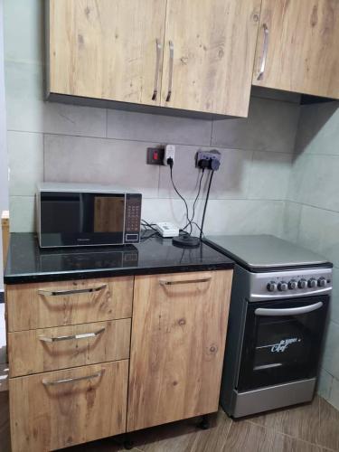a kitchen with a microwave oven and a stove at cari haven homes in Buwate