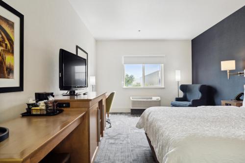a hotel room with a bed and a flat screen tv at Sonesta Essential Vacaville Napa Valley in Vacaville