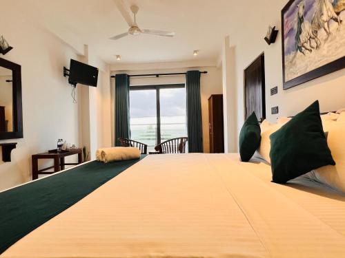 a large bed in a room with a large window at Ocean Front Villa in Hikkaduwa