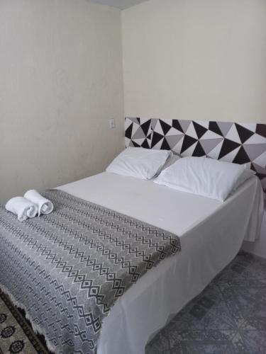 a bedroom with a bed with a black and white comforter at Vilmar suítes in Maricá