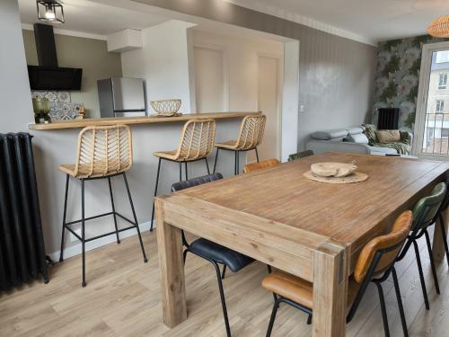une cuisine et une salle à manger avec une table et des chaises en bois dans l'établissement Le Précieux, à Fécamp