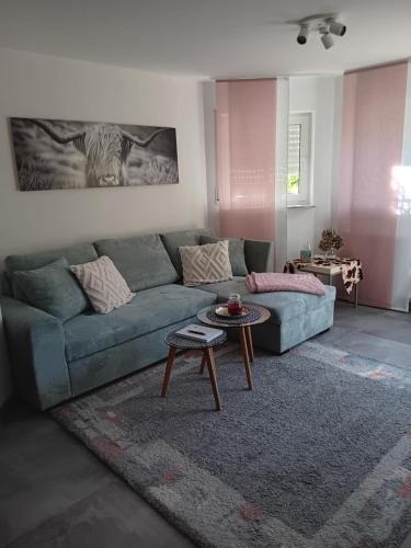 a living room with a blue couch and a table at Ferienwohnung Daheim in Achstetten