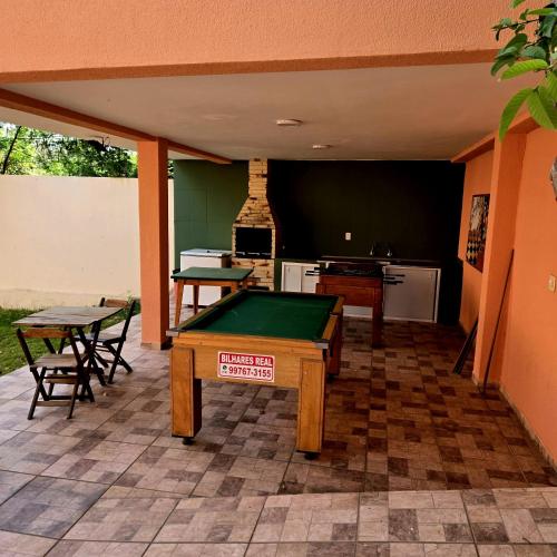 a patio with a pool table and a kitchen at Pousada Recanto Passarela in Aparecida