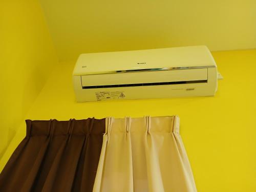 a printer sitting on a wall next to a curtain at Hill View Paka Homestay in Paka