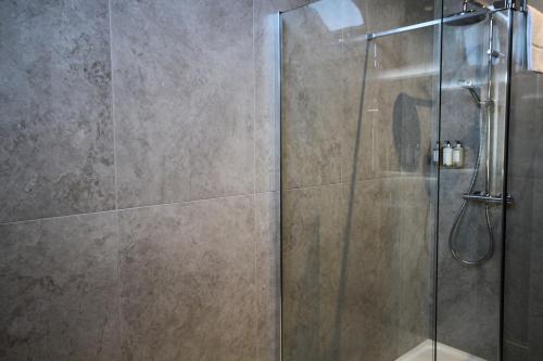 a shower with a glass door in a bathroom at Coach & Horses Dersingham in Dersingham