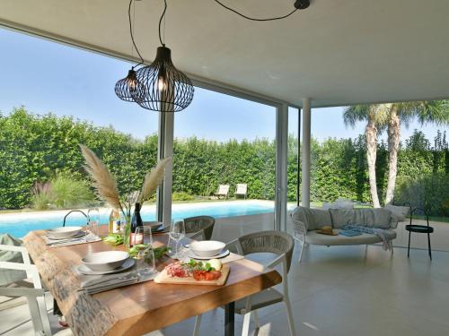 a dining room with a table and a pool at VILLA MANDORLO 4, Emma Villas in Ragusa