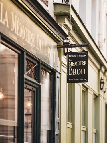 a store with signs on the side of a building at Hotel Madeleine De Senlis in Paris