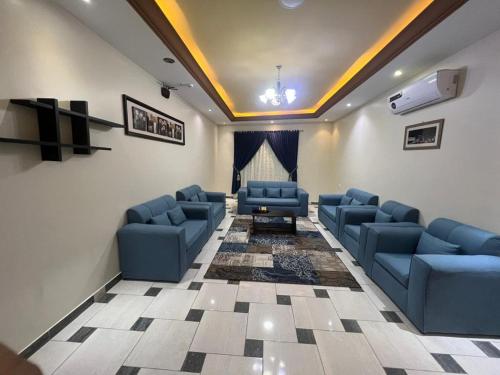a waiting room with blue couches and a stage at خزامى ابها للشقق المخدومة in Abha