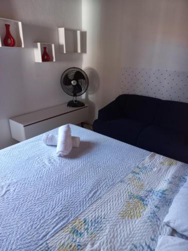 a bedroom with a bed with a pillow and a fan at Vilmar suítes in Maricá