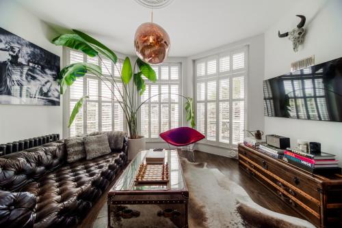 a living room with a couch and a table at Primrose Boutique Home in London