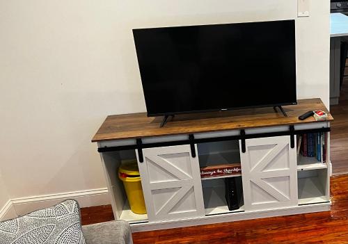 a tv stand with a television on top of it at Spacious 3 BR Ewing Home -Quiet in Trenton