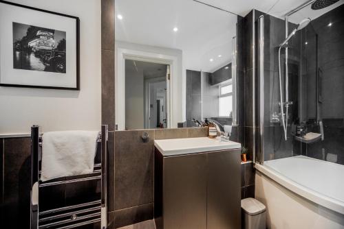 a bathroom with a tub and a sink and a shower at Primrose Boutique Home in London