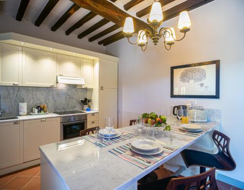 a kitchen with a table with plates and glasses on it at Casa Livio, a garden with a view in Gaiole in Chianti