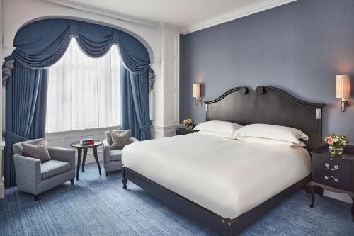 a bedroom with a bed and a chair and a window at The Connaught, Maybourne in London