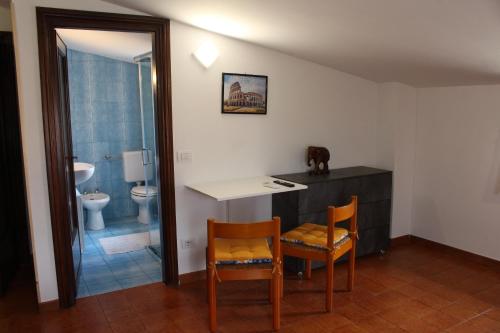 a bathroom with a table and two chairs and a toilet at Casa Trevisan in Marco Simone