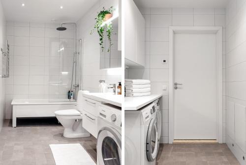 a white bathroom with a washing machine in it at Stylish Waterfront Apt Stockholm in Stockholm