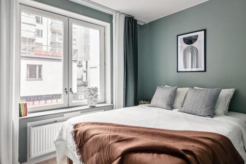 a bedroom with a bed and a window at Stylish Waterfront Apt Stockholm in Stockholm