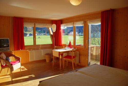 ein Schlafzimmer mit einem Bett und einem Tisch in einem Zimmer in der Unterkunft Hotel Garni Hostatt in Engelberg