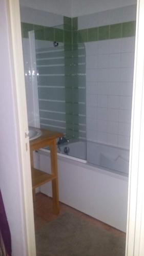 a bathroom with a tub and a sink and a table at CÉVENNES MAISONNETTE DANS RÉSIDENCE DE VACANCES in Sauve