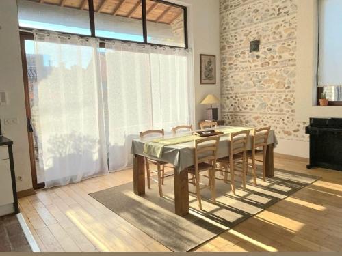 a dining room with a table and some chairs at Magnifique demeure de charme ! in Torreilles