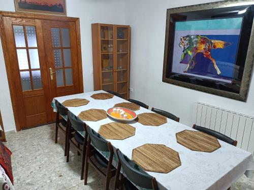 a dining room with a table with chairs and a television at Casa De Aventuras ideal for large groups in Bácor