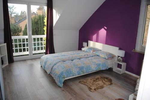 Schlafzimmer mit lila Wänden und einem Bett mit einem Teppich in der Unterkunft Villa Donar in Köln