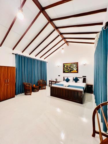 a bedroom with a bed and blue drapes at Ocean Front Villa in Hikkaduwa