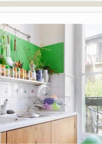 - une cuisine avec un évier et un mur vert dans l'établissement Chambre spacieuse quartier longchamp, à Marseille